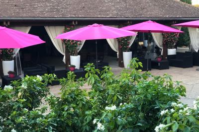 Arrangements floraux sur des supports en bois disposés sur une table recouverte d'une nappe blanche devant un mur en pierre.