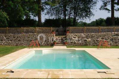 Chambre avec lit double, armoire en bois, murs jaunes, lampes de chevet et accès partiel à une salle de bain.