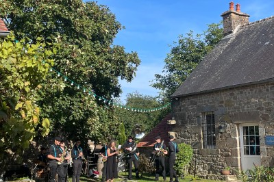 Groupe de personnes rassemblées dans un jardin verdoyant par une journée ensoleillée.