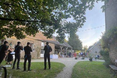 Groupe de personnes rassemblées dans un jardin verdoyant par une journée ensoleillée.