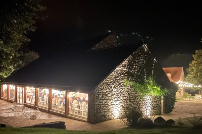 Groupe de personnes rassemblées dans un jardin verdoyant par une journée ensoleillée.