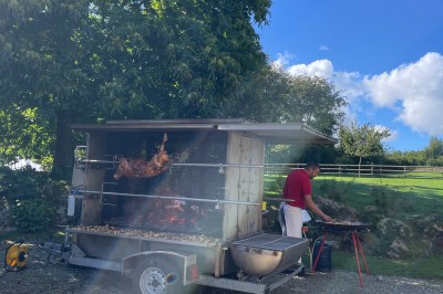 Groupe de personnes rassemblées dans un jardin verdoyant par une journée ensoleillée.