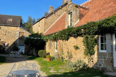 Groupe de personnes rassemblées dans un jardin verdoyant par une journée ensoleillée.