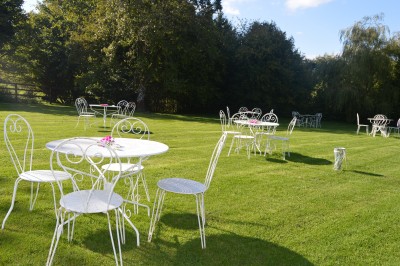 Groupe de personnes rassemblées dans un jardin verdoyant par une journée ensoleillée.