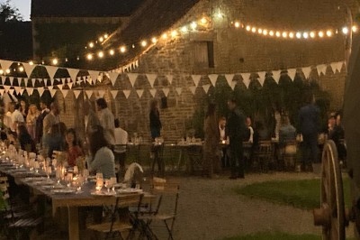Groupe de personnes rassemblées dans un jardin verdoyant par une journée ensoleillée.