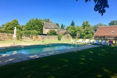 Groupe de personnes rassemblées dans un jardin verdoyant par une journée ensoleillée.