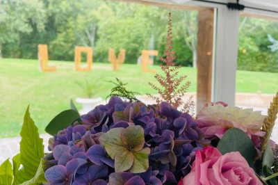 Groupe de personnes rassemblées dans un jardin verdoyant par une journée ensoleillée.