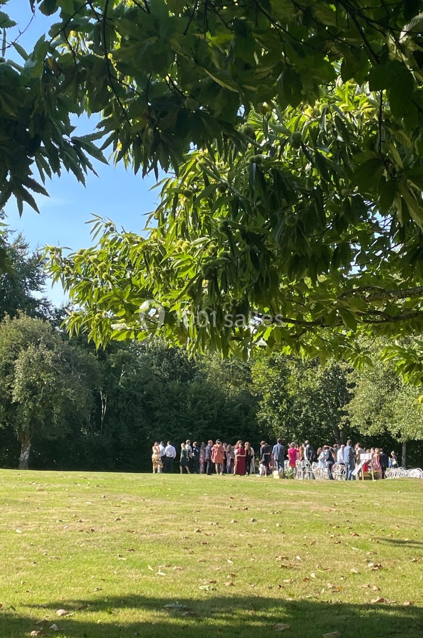 Un groupe de personnes rassemblées dans un parc verdoyant sous un ciel dégagé.
