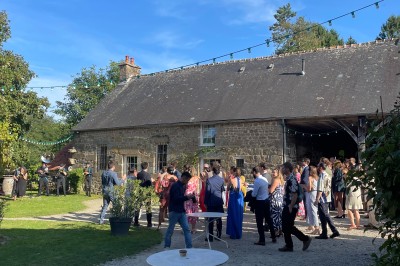 Groupe de personnes rassemblées dans un jardin verdoyant par une journée ensoleillée.