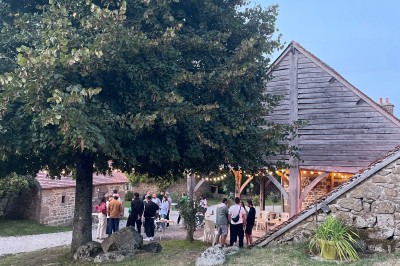 Groupe de personnes rassemblées dans un jardin verdoyant par une journée ensoleillée.