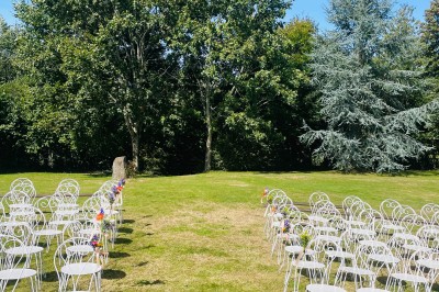 Groupe de personnes rassemblées dans un jardin verdoyant par une journée ensoleillée.
