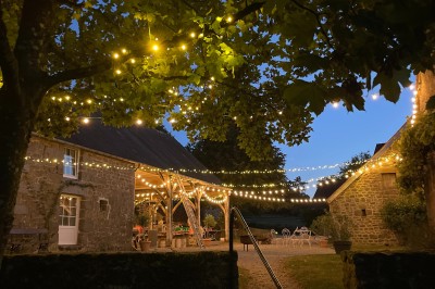 Groupe de personnes rassemblées dans un jardin verdoyant par une journée ensoleillée.