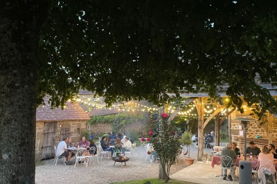 Groupe de personnes rassemblées dans un jardin verdoyant par une journée ensoleillée.