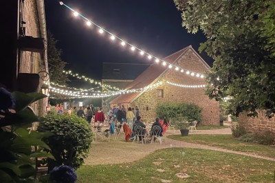 Groupe de personnes rassemblées dans un jardin verdoyant par une journée ensoleillée.