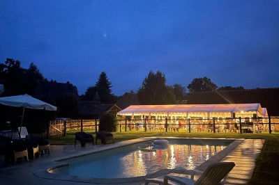 Groupe de personnes rassemblées dans un jardin verdoyant par une journée ensoleillée.