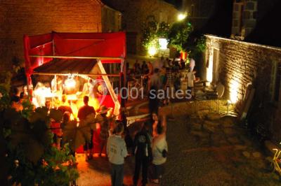 Chambre avec lit double, armoire en bois, murs jaunes, lampes de chevet et accès partiel à une salle de bain.
