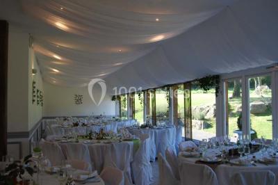 Chambre avec lit double, armoire en bois, murs jaunes, lampes de chevet et accès partiel à une salle de bain.