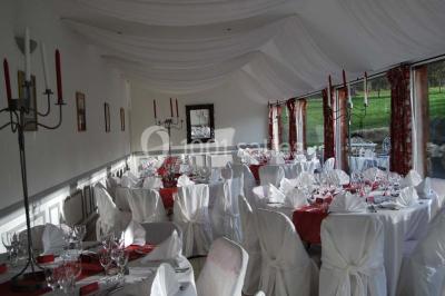 Chambre avec lit double, armoire en bois, murs jaunes, lampes de chevet et accès partiel à une salle de bain.