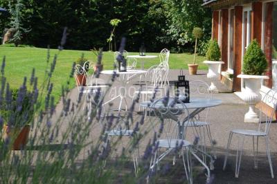 Chambre avec lit double, armoire en bois, murs jaunes, lampes de chevet et accès partiel à une salle de bain.