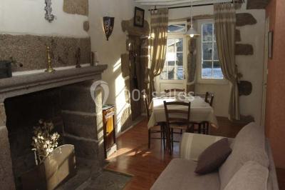 Chambre avec lit double, armoire en bois, murs jaunes, lampes de chevet et accès partiel à une salle de bain.