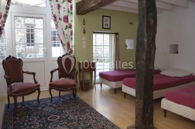 Chambre avec lit double, armoire en bois, murs jaunes, lampes de chevet et accès partiel à une salle de bain.