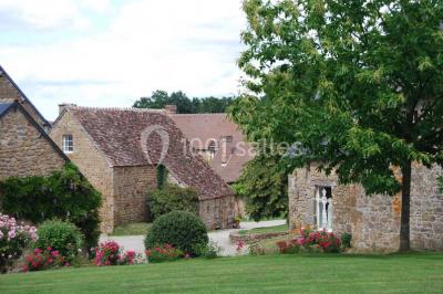 Chambre avec lit double, armoire en bois, murs jaunes, lampes de chevet et accès partiel à une salle de bain.