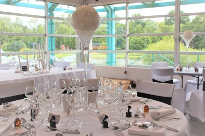 Salle de bain moderne avec lavabo, miroir, toilettes suspendues et douche en arrière-plan.