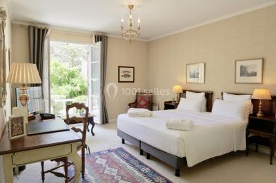 Une femme reçoit un massage sur une table dans une pièce chaleureuse avec des rideaux, des bougies et une lumière tamisée.