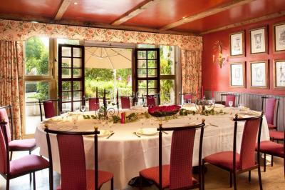 Une femme reçoit un massage sur une table dans une pièce chaleureuse avec des rideaux, des bougies et une lumière tamisée.