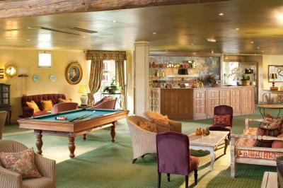 Une femme reçoit un massage sur une table dans une pièce chaleureuse avec des rideaux, des bougies et une lumière tamisée.