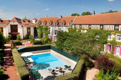 Une femme reçoit un massage sur une table dans une pièce chaleureuse avec des rideaux, des bougies et une lumière tamisée.