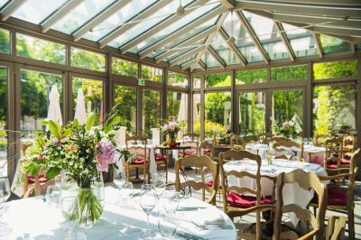 Une femme reçoit un massage sur une table dans une pièce chaleureuse avec des rideaux, des bougies et une lumière tamisée.