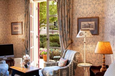 Une femme reçoit un massage sur une table dans une pièce chaleureuse avec des rideaux, des bougies et une lumière tamisée.