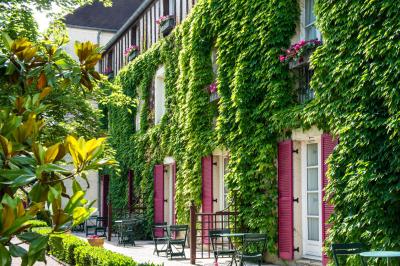Une femme reçoit un massage sur une table dans une pièce chaleureuse avec des rideaux, des bougies et une lumière tamisée.