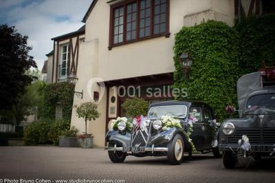 Une femme reçoit un massage sur une table dans une pièce chaleureuse avec des rideaux, des bougies et une lumière tamisée.