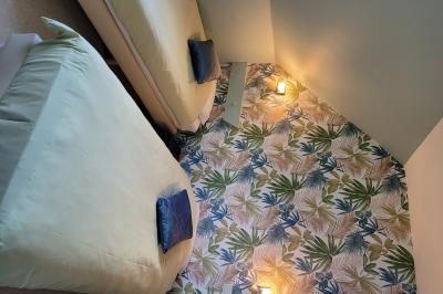 Une personne à vélo sur un chemin de campagne bordé de verdure, sous un ciel bleu avec quelques nuages.