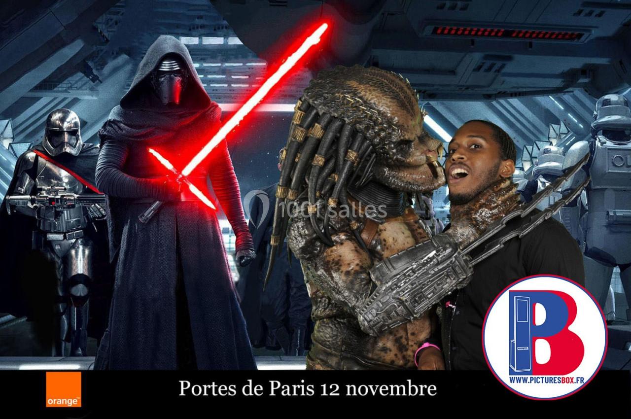 Un homme pose avec un costume de Predator, devant un décor de science-fiction avec des personnages armés.