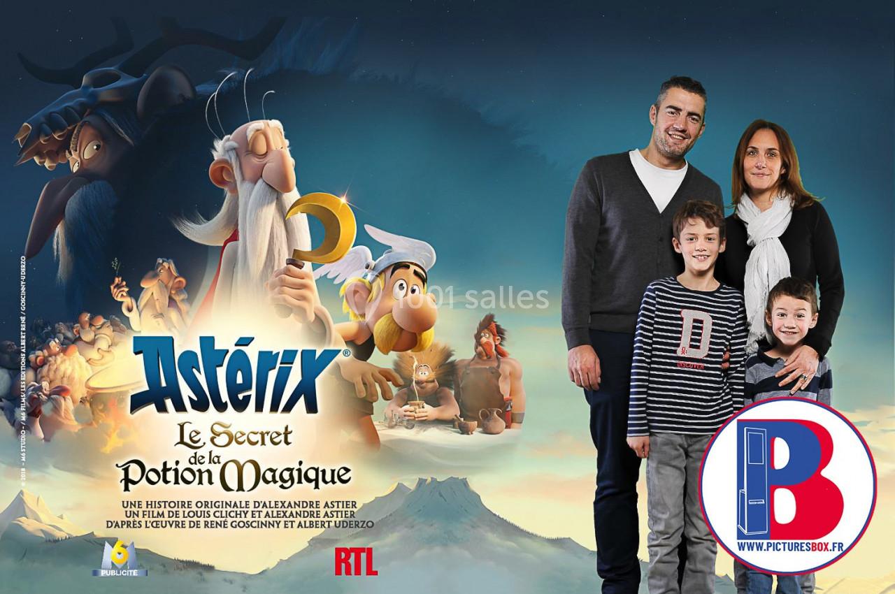 Affiche du film ’Astérix : Le Secret de la Potion Magique’ avec des personnages animés et une famille posant à droite.