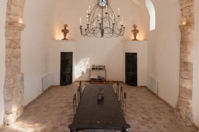 Portail en fer forgé ouvrant sur un paysage de vignes, avec des montagnes enneigées visibles à l'horizon.