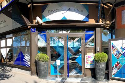 Salle de réunion avec tables disposées en U, bouteilles d'eau et gobelets, panneau d'information en arrière-plan.