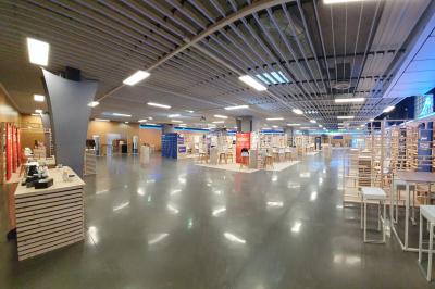 Salle de réunion avec tables disposées en U, bouteilles d'eau et gobelets, panneau d'information en arrière-plan.