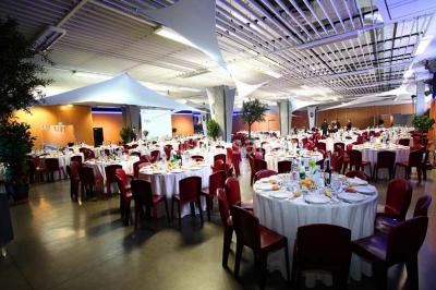 Salle de réunion avec tables disposées en U, bouteilles d'eau et gobelets, panneau d'information en arrière-plan.