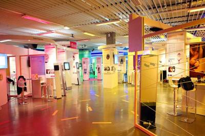 Salle de réunion avec tables disposées en U, bouteilles d'eau et gobelets, panneau d'information en arrière-plan.