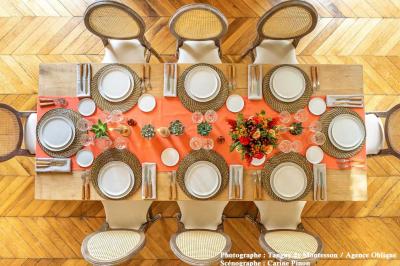 Une voiture de luxe bleue exposée dans un showroom, un homme examine l'intérieur par la portière ouverte.