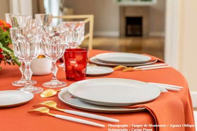 Une voiture de luxe bleue exposée dans un showroom, un homme examine l'intérieur par la portière ouverte.