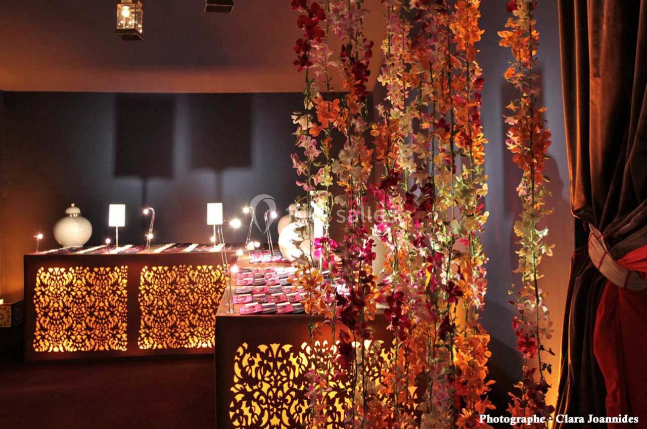 Décoration intérieure avec guirlandes de fleurs suspendues et meubles éclairés par des motifs ajourés.