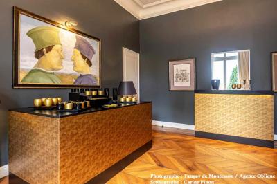 Miniature Options Orléans #24 Salle lumineuse avec parquet en bois, table ronde dressée avec nappe rouge, et moulures décoratives au plafond.