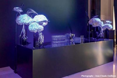 Décoration intérieure avec guirlandes de fleurs suspendues et meubles rétroéclairés ornés de motifs ajourés.