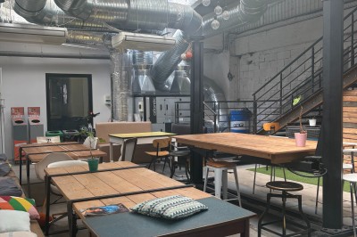 Miniature Location salle Toulouse (Haute-Garonne) - Lab'Oïkos - Cité de la RSE et de l'impact #1 Espace de coworking lumineux avec des tables en bois, des chaises variées et un plafond industriel avec des conduits…