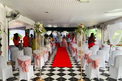 Un couple de mariés danse au centre d'une salle décorée, entouré d'invités applaudissant.